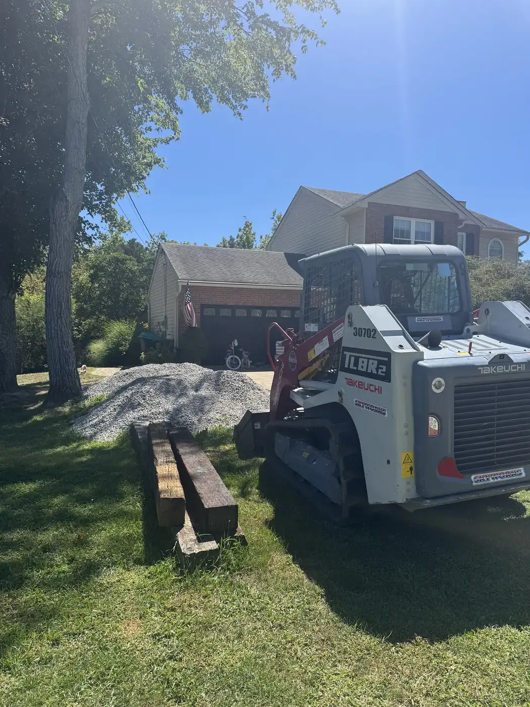 Phelps track loader moving gravel in a back yard