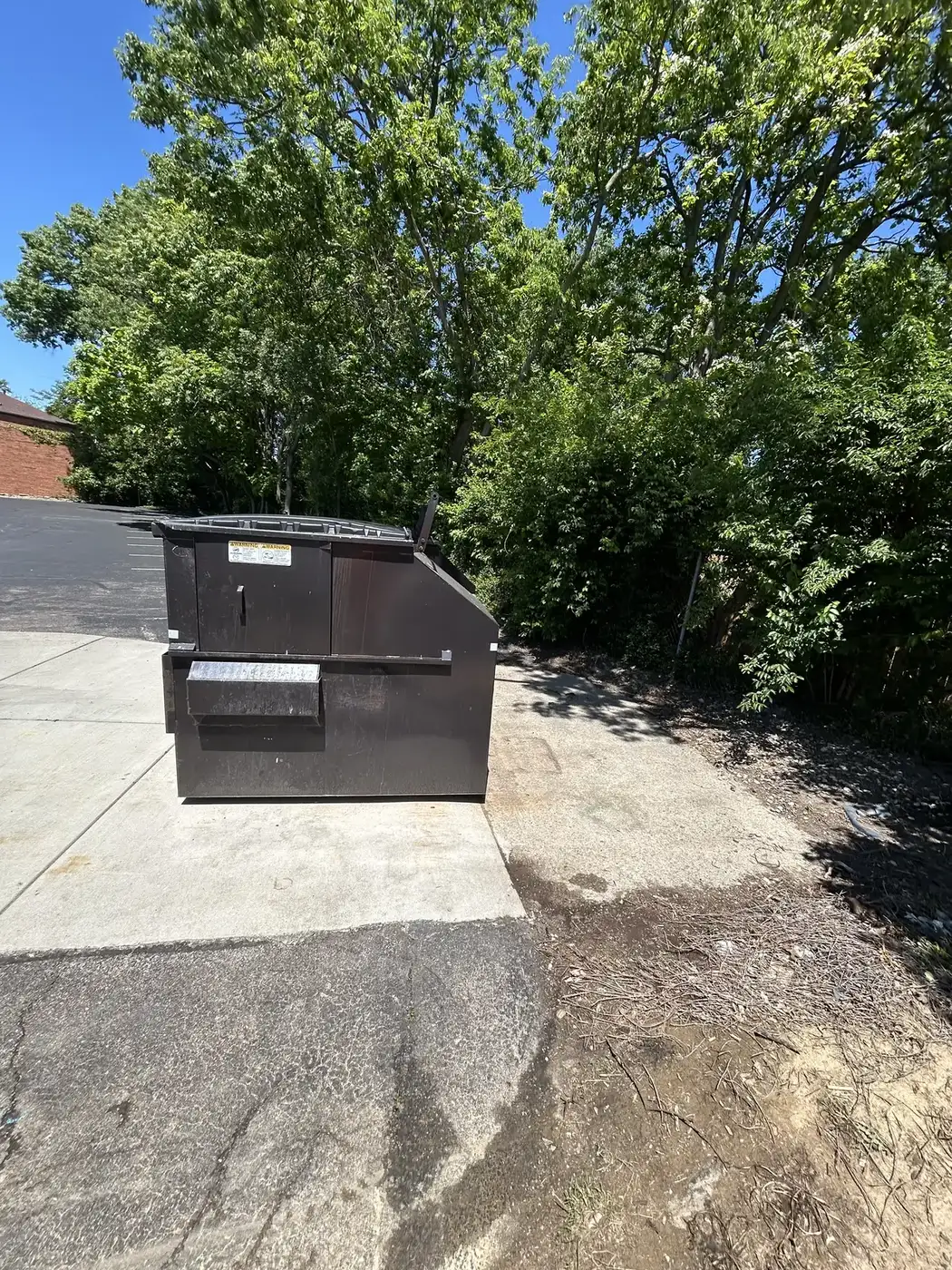 Phelps dumpster set on a concrete pad for a property cleanup